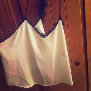 White flowy textured tank with a black lace trim